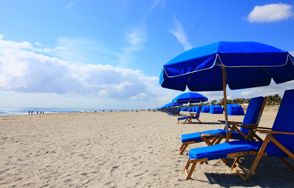 Beach with Blue Umbrellas and Lounge Chairs